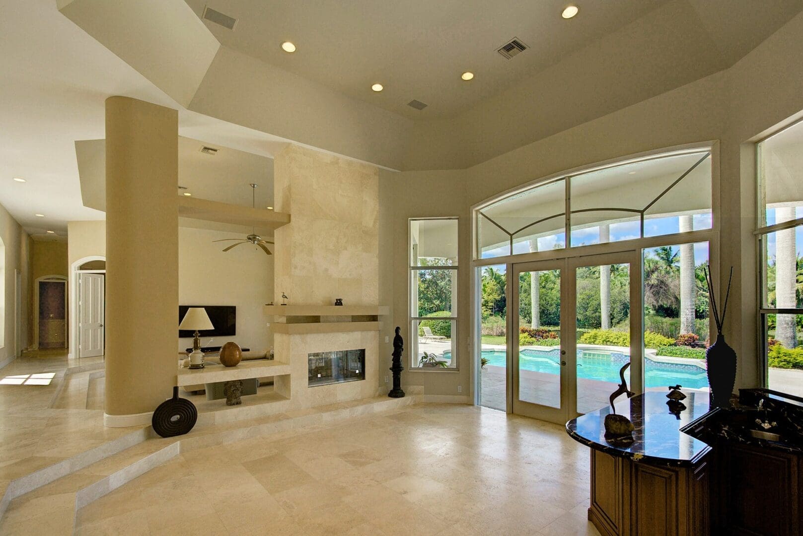 A living room with a fireplace and a large glass door.