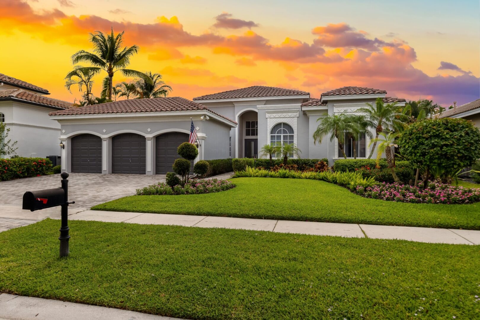 A large house with a lot of grass on the front lawn.