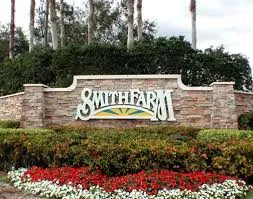 A sign that says smith farm in front of some bushes