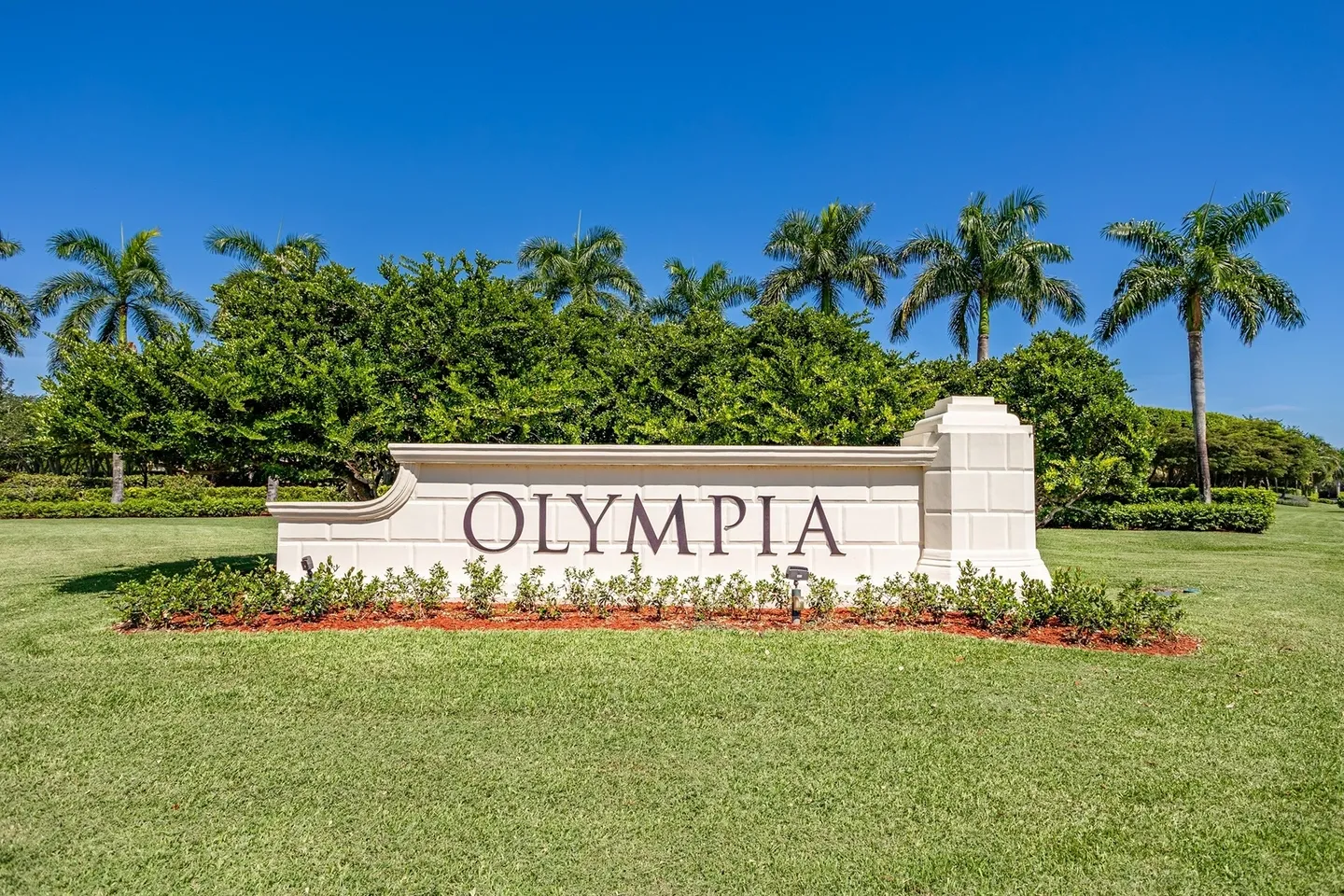 A sign that says olympia in front of some trees.