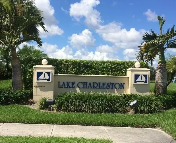 A sign that says lake charleston in front of some trees