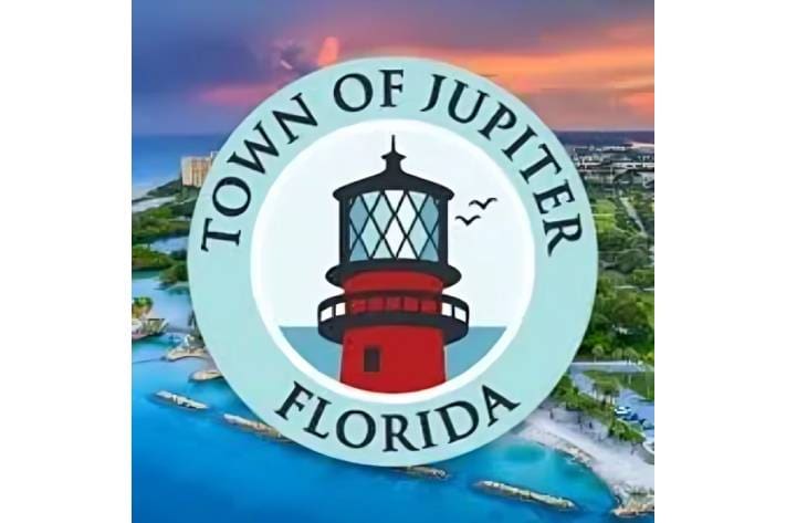 A town of jupiter seal is shown in front of the ocean.